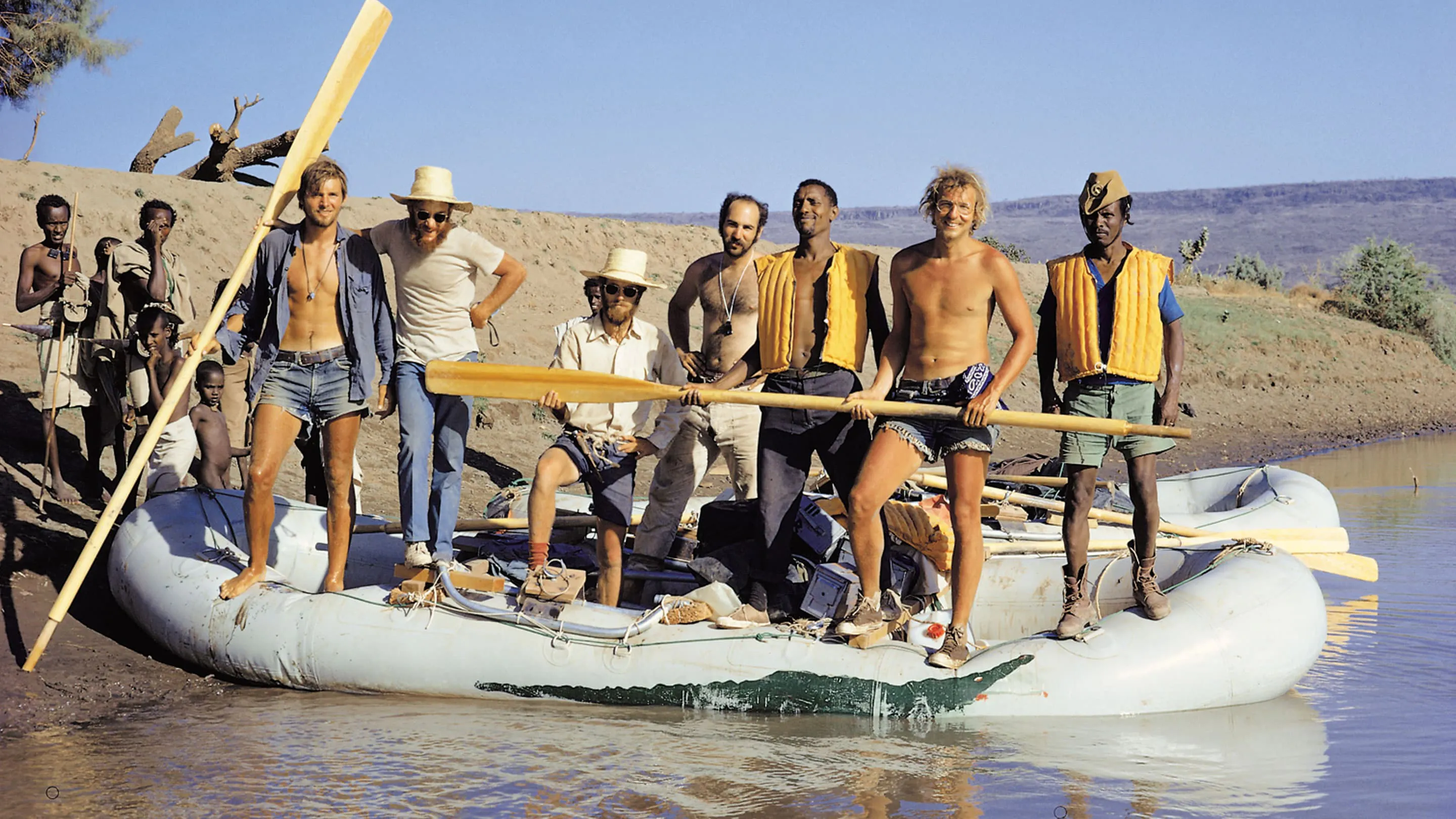 A group of men standing on a raft in a river.