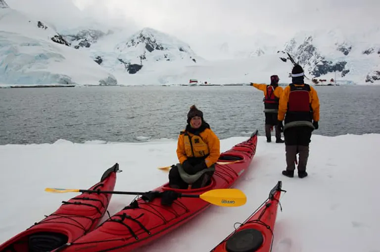 smiling woman about to embark on a kayak trip in the cold waters of Antarctica
