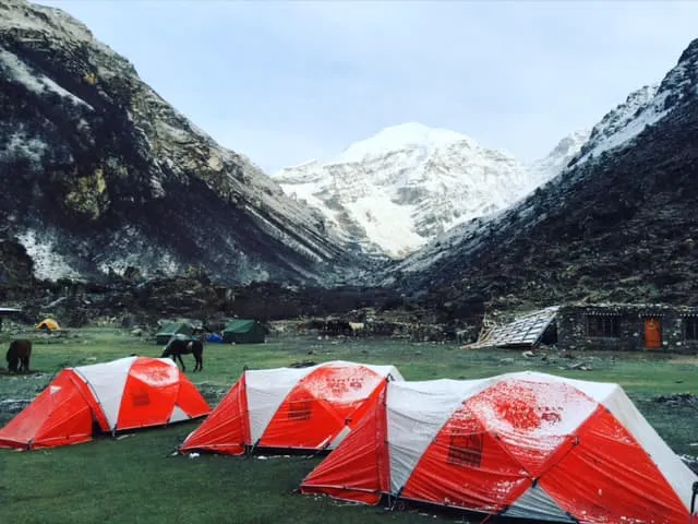 A group of tents set up in front of mountains.