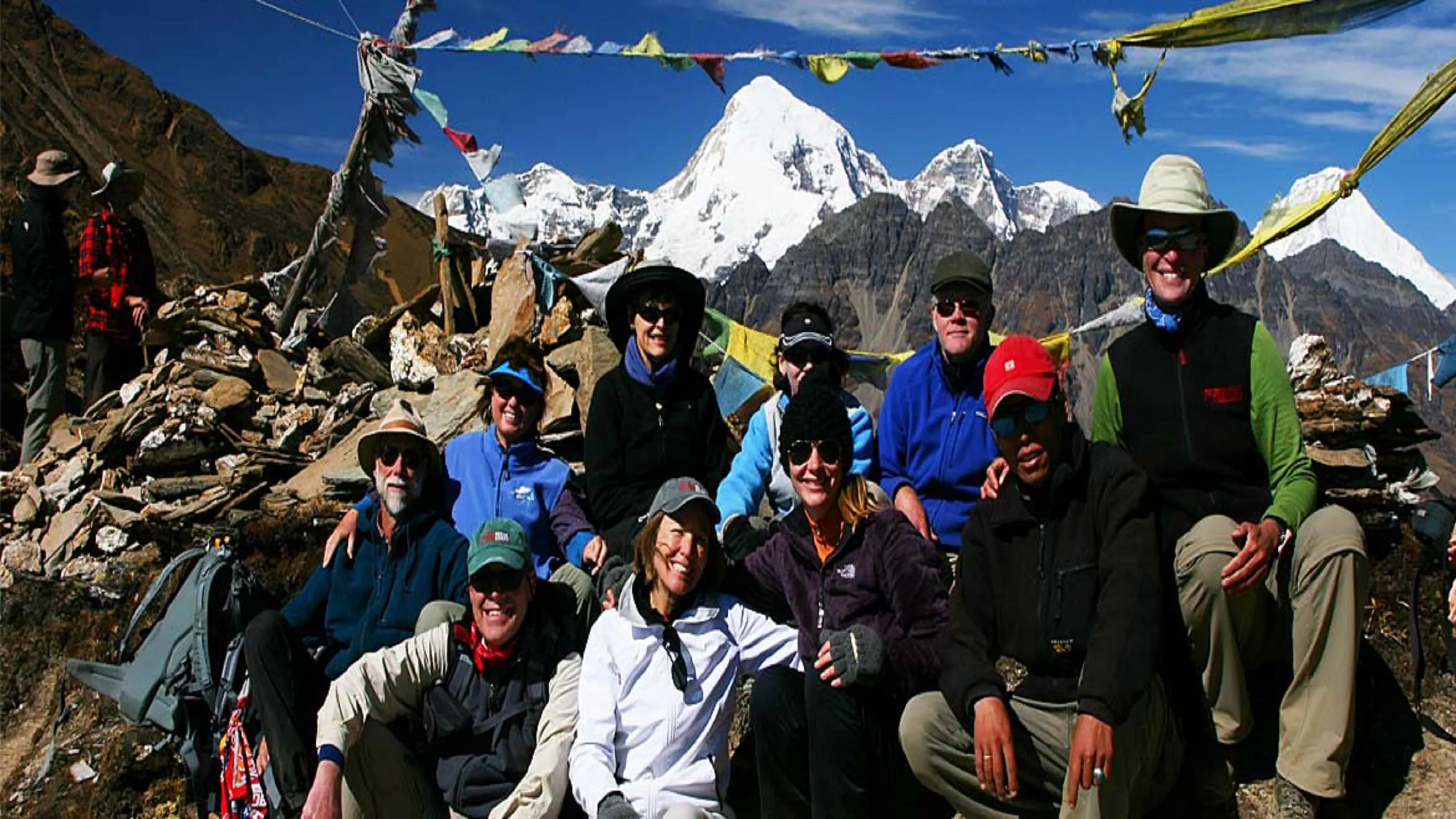 A group of people posing for a photo in front of mountains.
