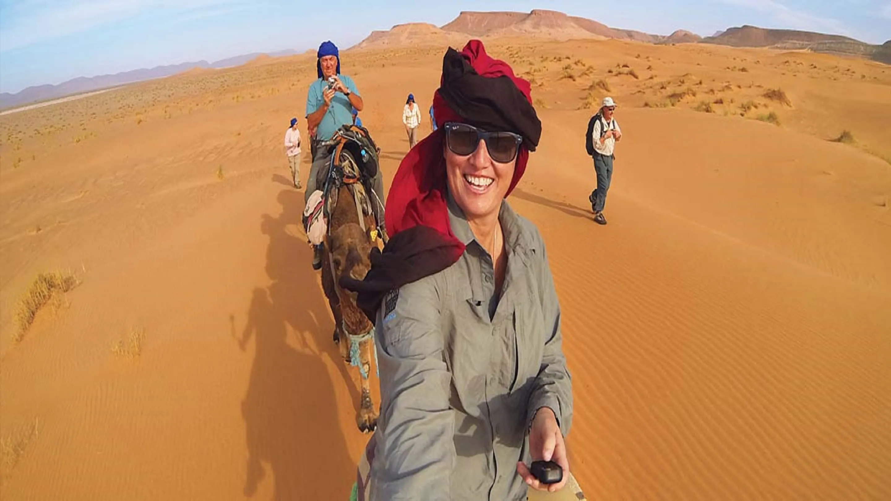 A group of people riding camels in the desert.