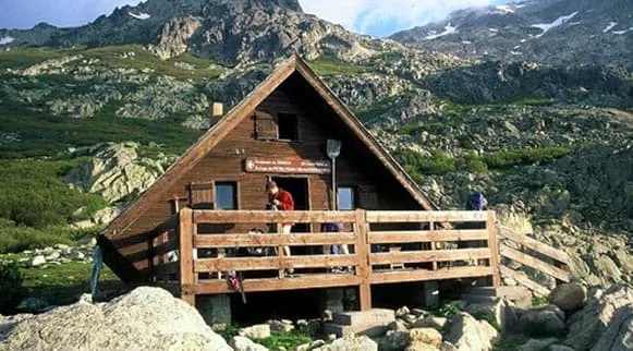 A wooden cabin on top of a mountain.