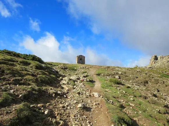 A small stone tower on top of a hill.