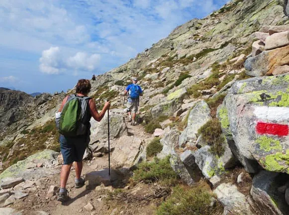 A group of people hiking up a mountain trail.