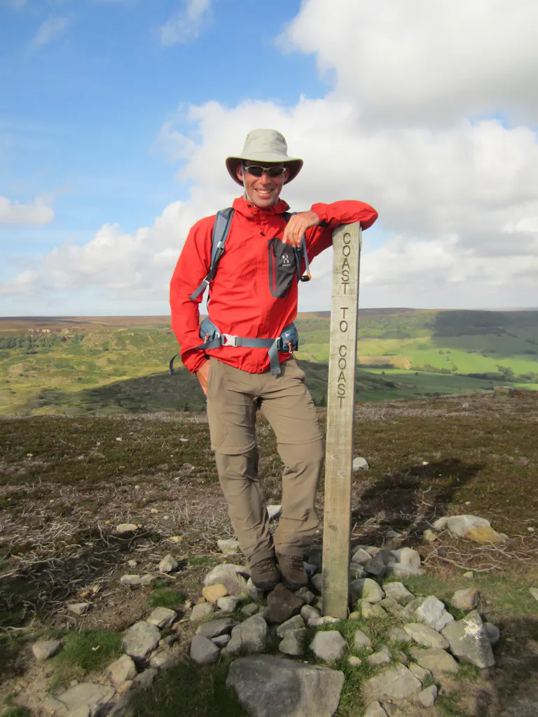 man posing next to coast to coast