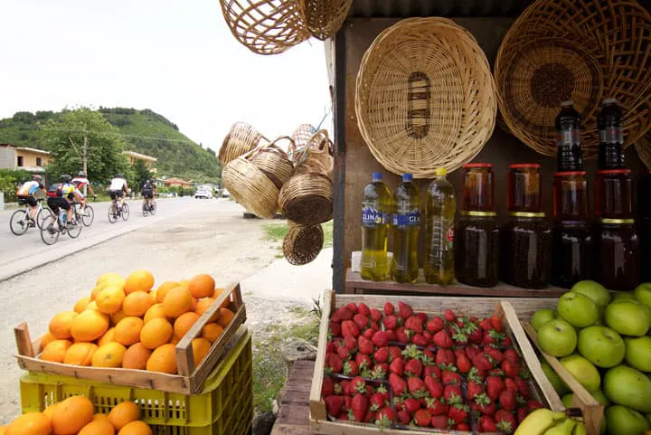 A fruit stand with baskets of fruit.