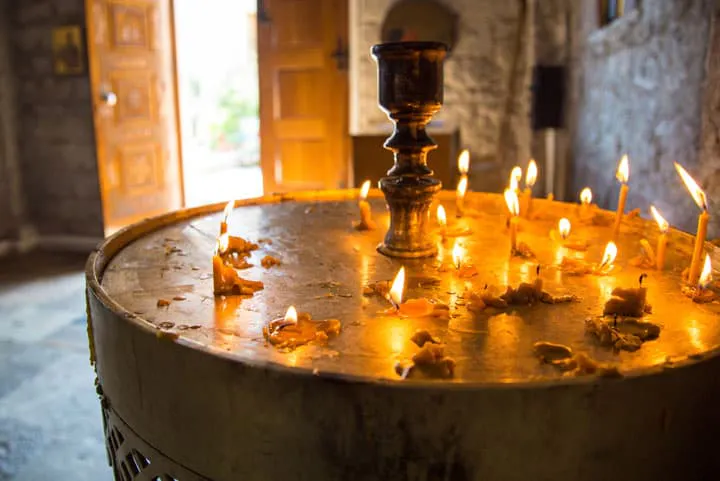 Lit candles on a table in a church.