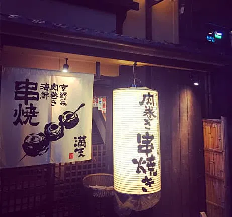 A lantern with a japanese sign hanging from it.