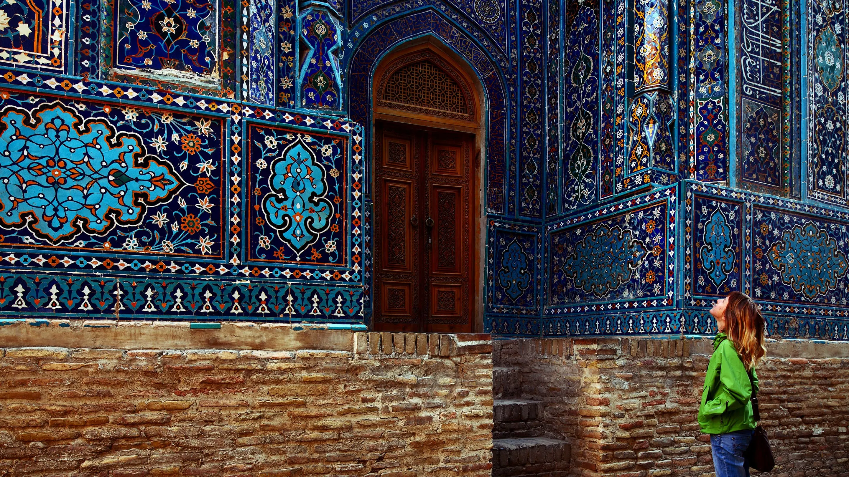 A woman standing in front of an ornate building.