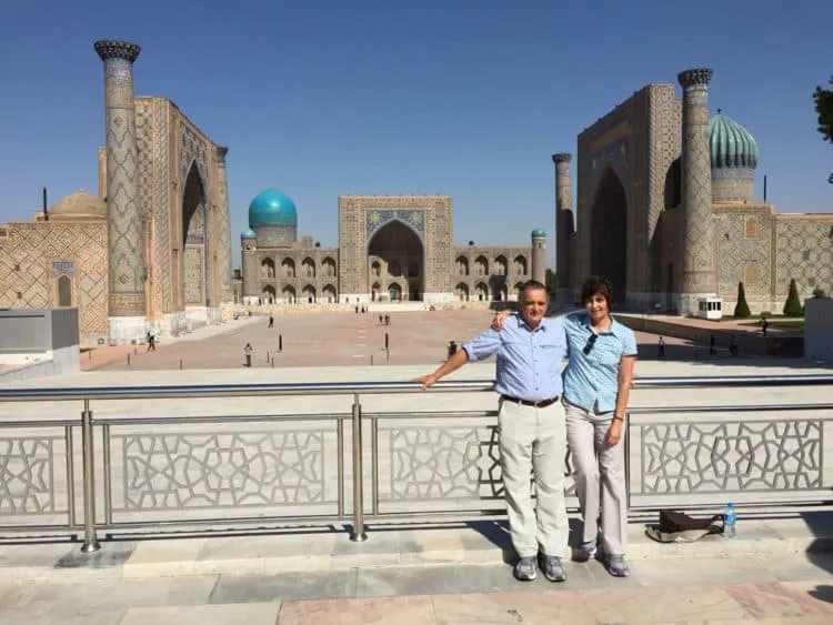A man and woman standing in front of a mosque.