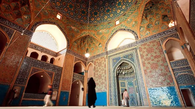 A woman explores an ornately decorated mosque on her travel adventure.