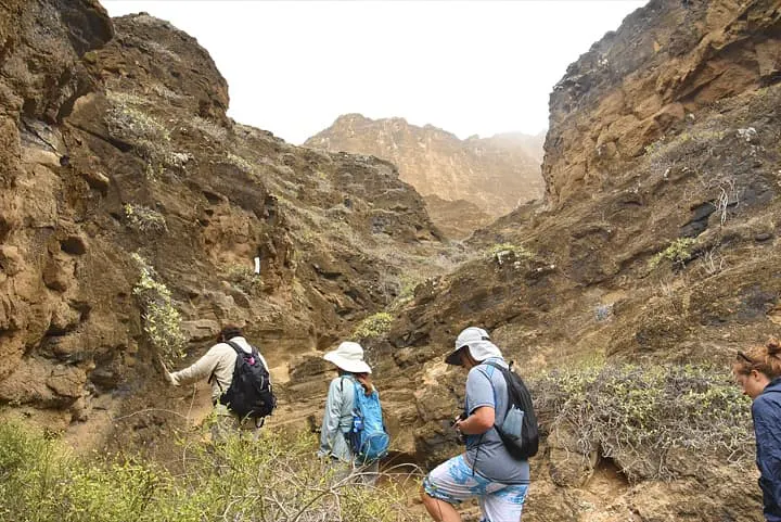 A group of people hiking through a rocky area.