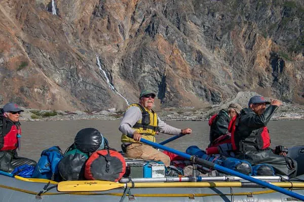 A group of people on a boat with a mountain in the background.