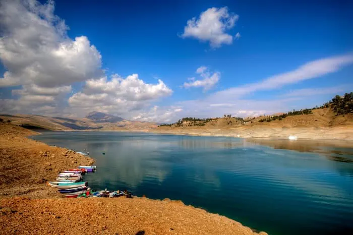 Boats are docked on the shore of a lake.