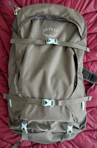 An osprey explorer backpack on a bed.