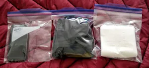 Three plastic bags with a pair of gloves and a pair of socks.