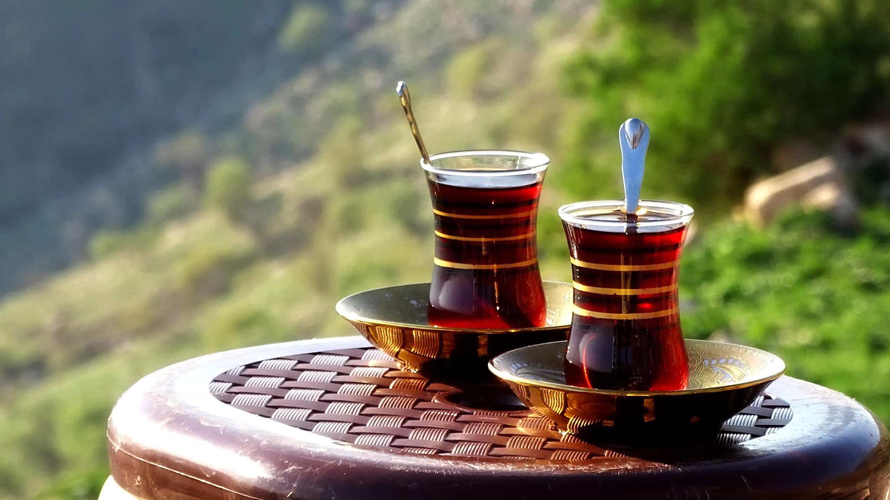 Two cups of tea sitting on top of a wooden table.