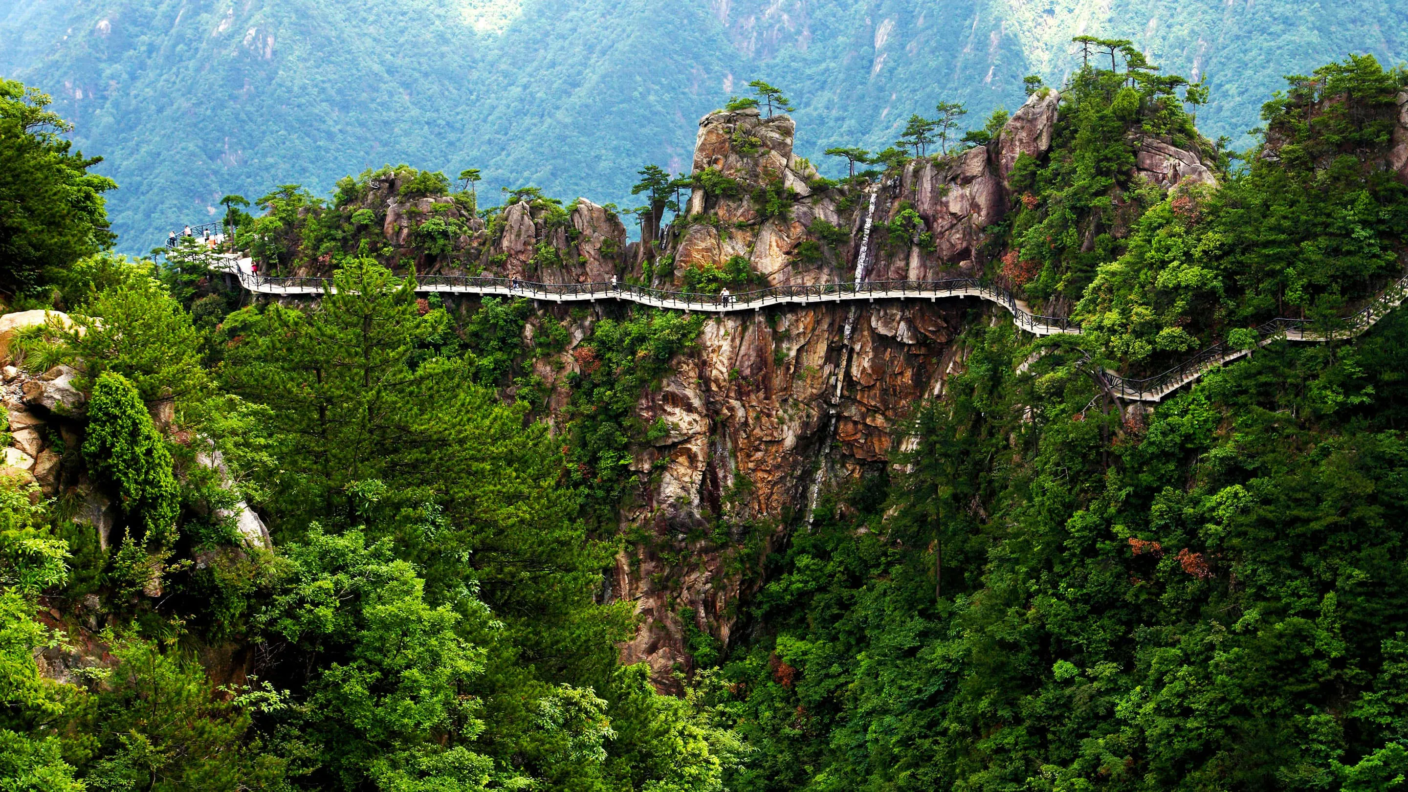 A bridge that goes over a cliff in a mountainous area.