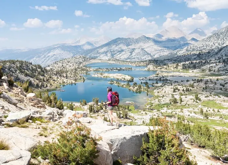 A hiker looking at a lake in the mountains.