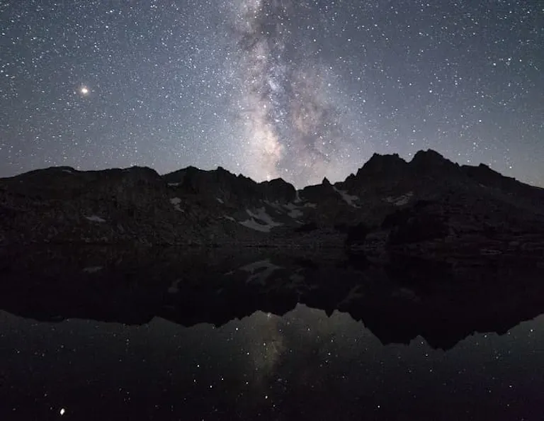 The milky and venus are reflected in a lake.
