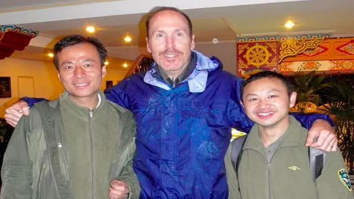 Three men posing for a photo in a restaurant.