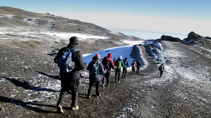 A group of people hiking up a snowy mountain.