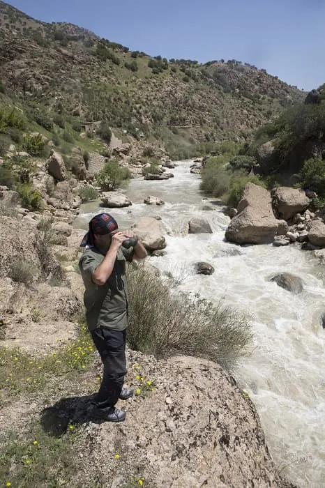 A man is taking a picture of a river.