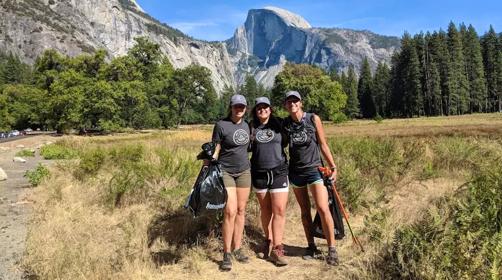 Three women standing in front of yosemite mountain.