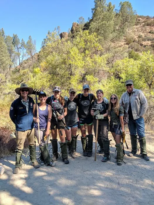 A group of people posing for a picture on a trail.