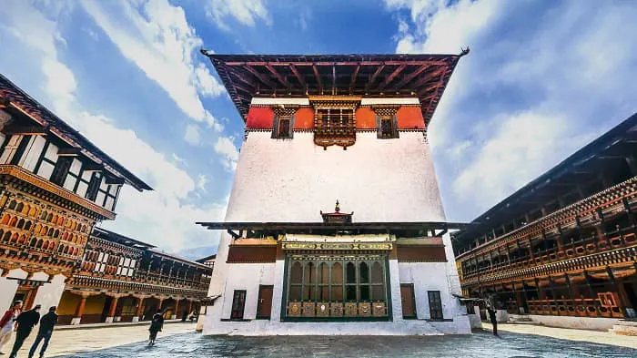 A building with a clock tower in the middle of a courtyard.