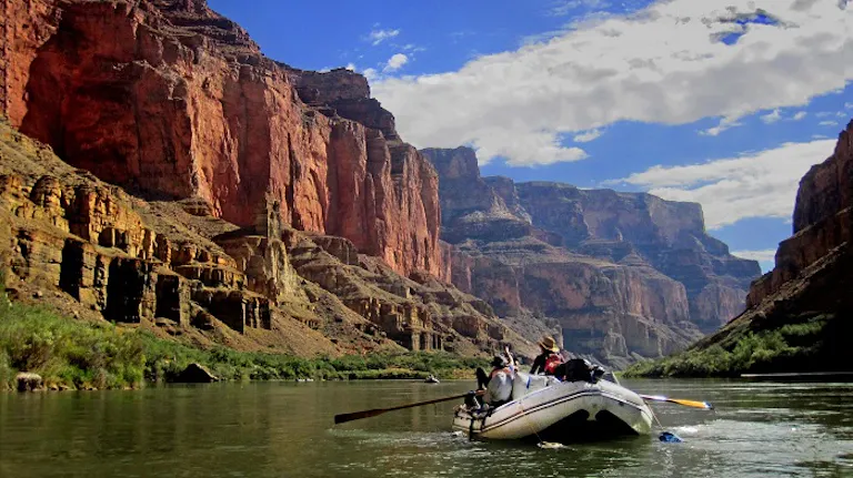 A group on a boat in the grand canyon enjoying cataract canyon rafting.