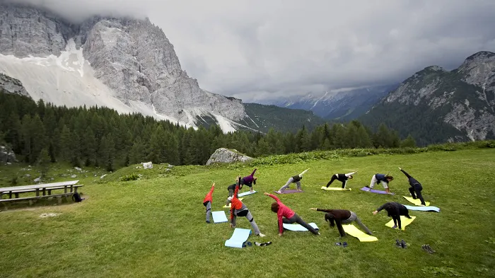 A group of people doing yoga in the mountains.