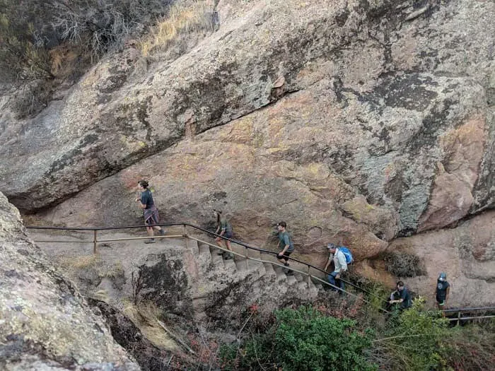A group of people walking up a rocky path.