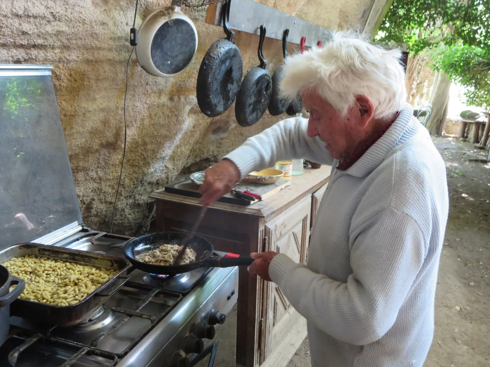 A man is cooking food in a frying pan.