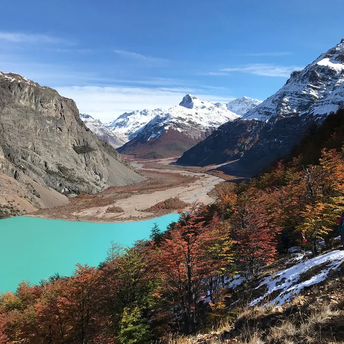 A blue lake in the mountains with mountains in the background.