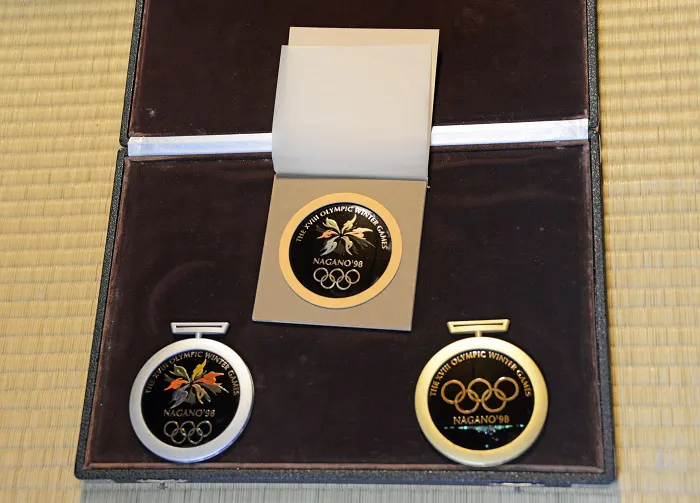 Three olympic medals in a case on a table.