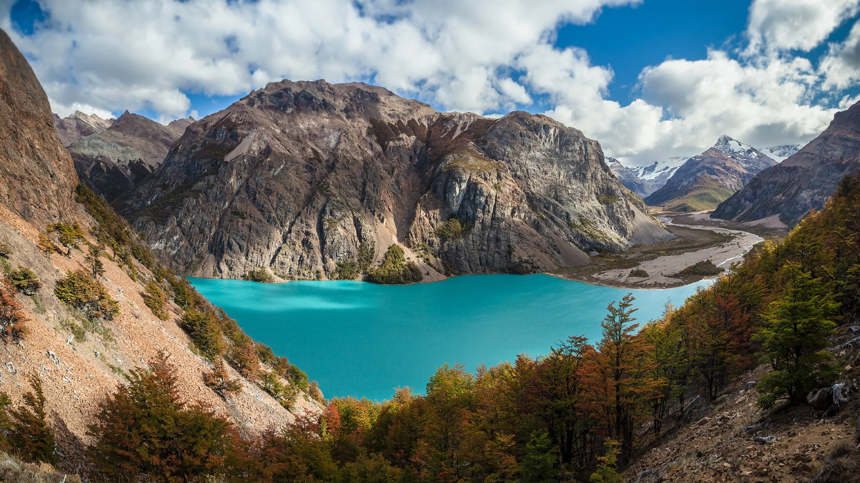 A blue lake surrounded by mountains and trees.