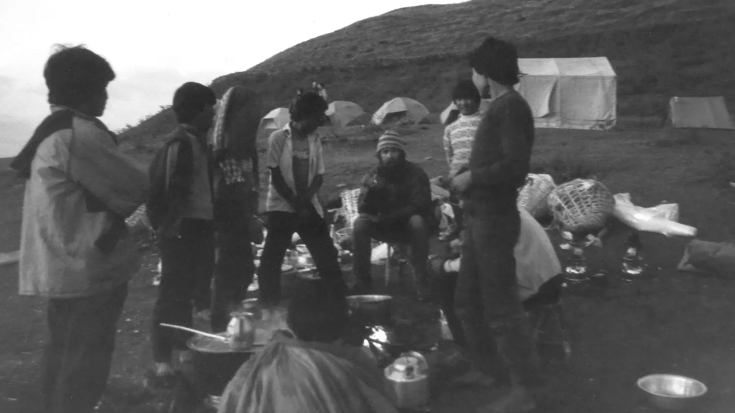 A group of people sitting around a campfire.
