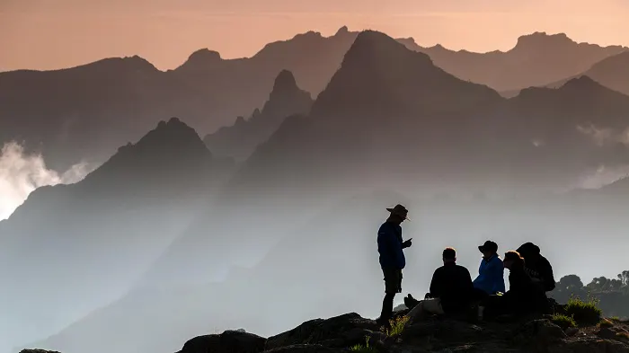 A group of people sitting on top of a mountain.