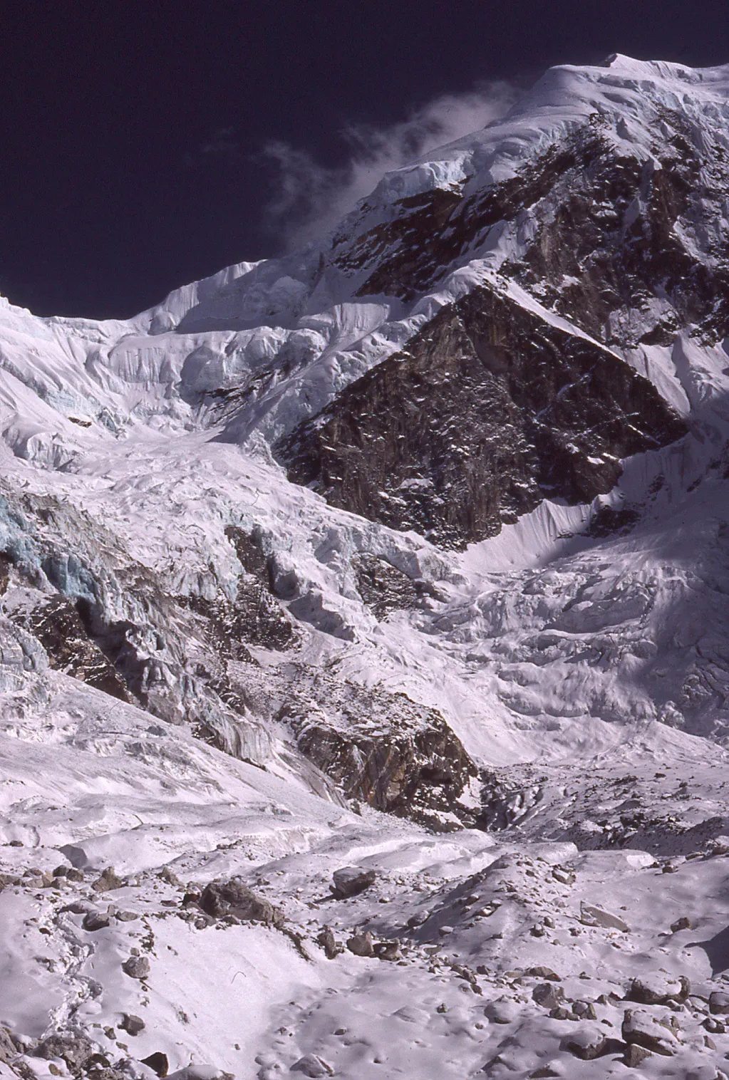 A snow covered mountain with a glacier in the background.
