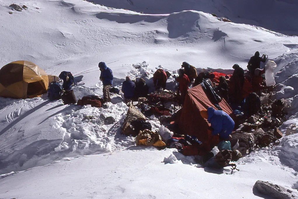 A group of people standing on top of a snow covered mountain.
