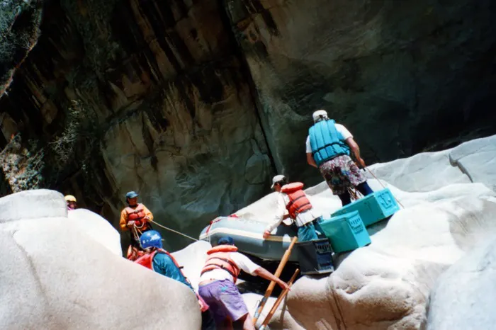 A group of people rafting down a canyon.