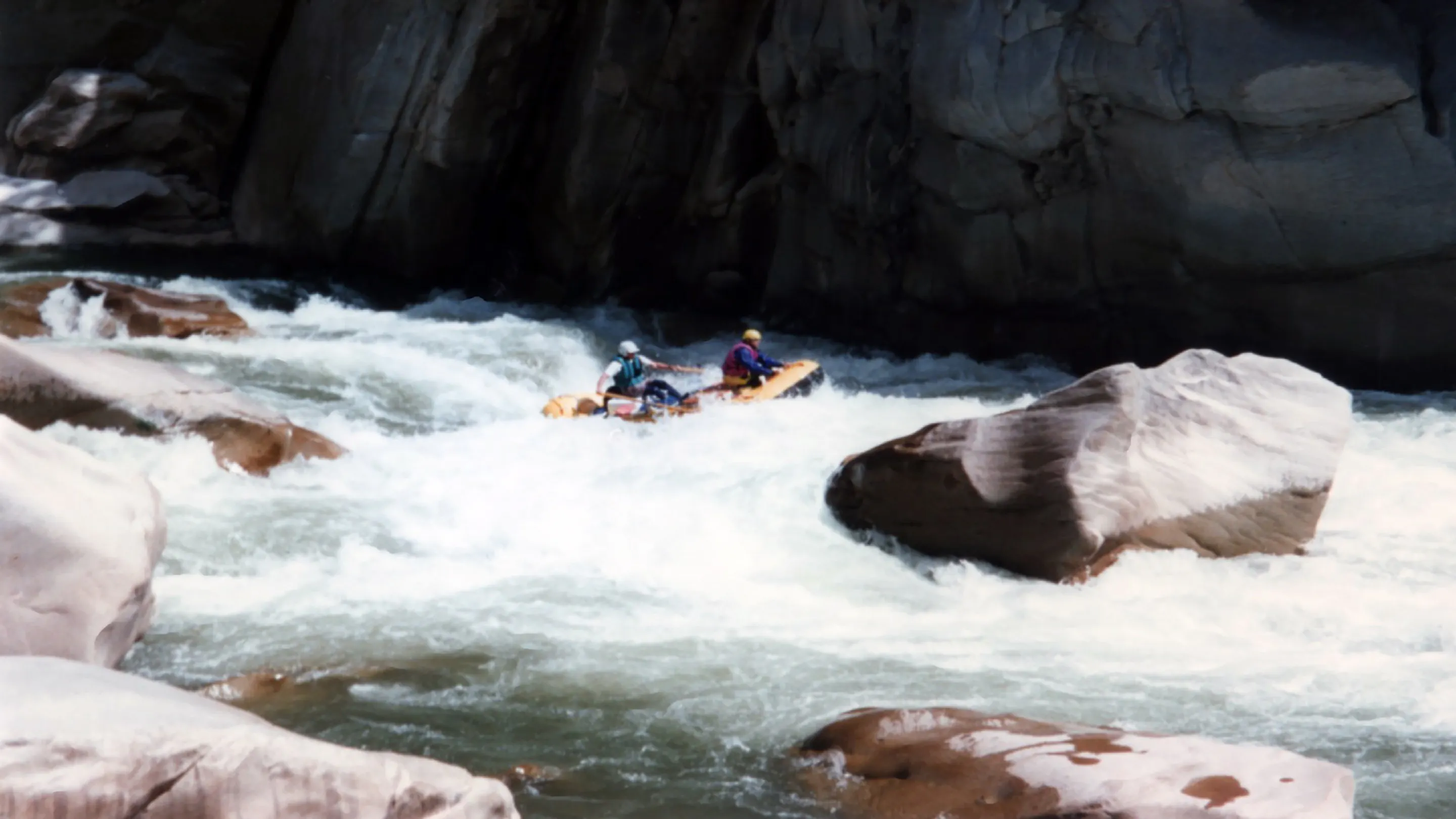 A group of people rafting down a river.