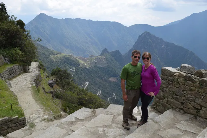 Two people standing on the steps of machu picchu.