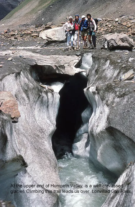 A group of people standing near an ice cave.