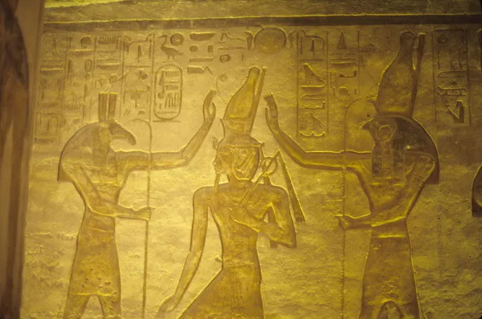 An egyptian relief depicting a pharaoh and two egyptians.