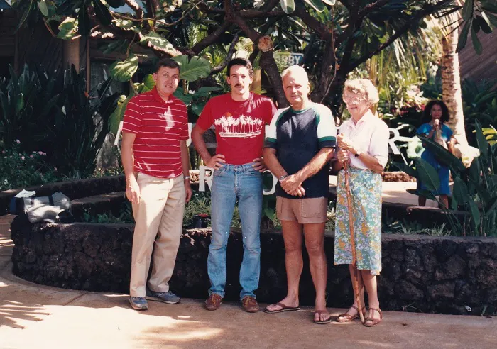A group of people standing in front of a tree.