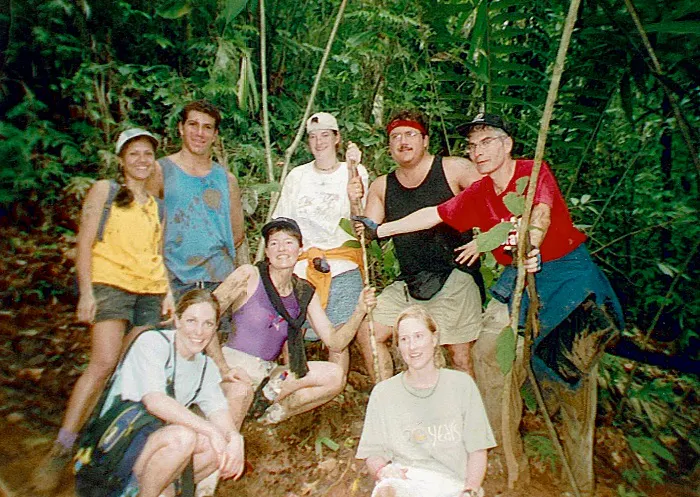 A group of people posing for a picture in the jungle.
