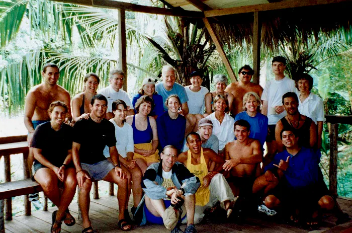 A group of people posing on a wooden deck.