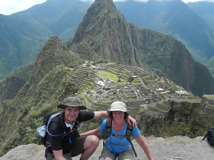 Two people posing for a photo on top of machu picchu.